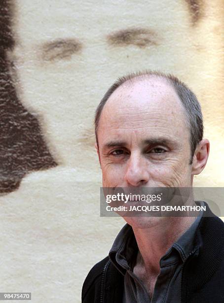 Jacques Desse, a French bookseller, poses on April 15, 2010 at the Paris Old Books fair in the Grand Palais in front of big print of the picture...