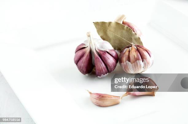 purple garlic on white plate - rude awakening stock pictures, royalty-free photos & images