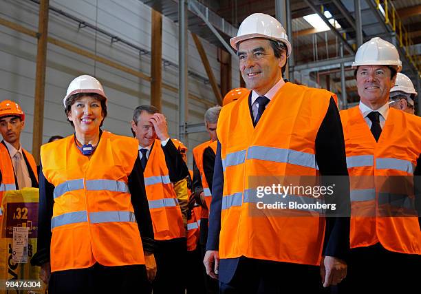 Roselyne Bachelot, France's health minister, left, and Francois Fillon, France's prime minister, center, listen during a tour of the Cie....