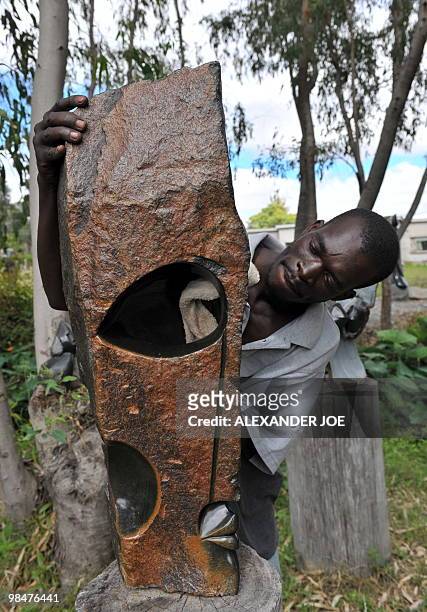 Zimbabwean artist Philip Mlima puts the finishing touch to his Shona Stone Sculpture called "Eye Witness" in Harare on April 15, 2010. Zimbabwe marks...