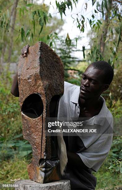 Zimbabwean artist Philip Mlima puts the finishing touch to his Shona Stone Sculpture called "Eye Witness" in Harare on April 15, 2010. Zimbabwe marks...