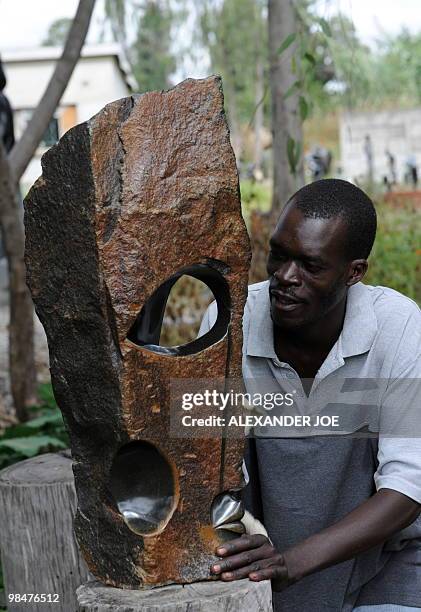 Zimbabwean artist Philip Mlima puts the finishing touch to his Shona Stone Sculpture called "Eye Witness" in Harare on April 15, 2010. Zimbabwe marks...