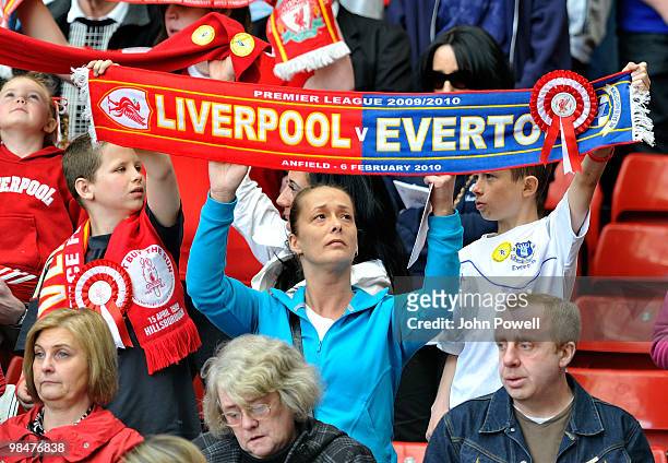 Supporters of Liverpool and Everton along with the family and friends of the 96 people who lost their lives at Hillsborough hold their scarves aloft...