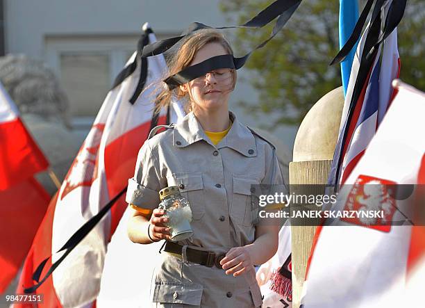 Scout girl walks with a candle inbetween Polish national flags in front of the presidential palace in Warsaw on April 15, 2010. The Polish...