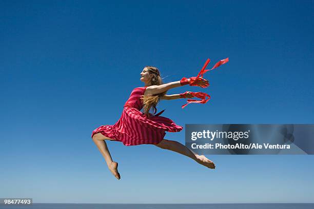 young woman leaping, midair - striped dress stock pictures, royalty-free photos & images