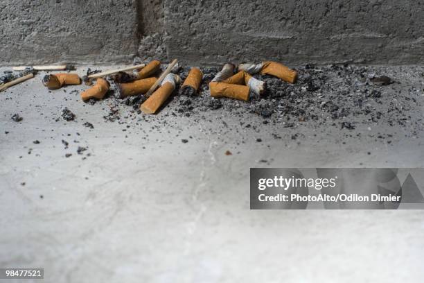 discarded cigarette butts on ground - zigarettenstummel stock-fotos und bilder