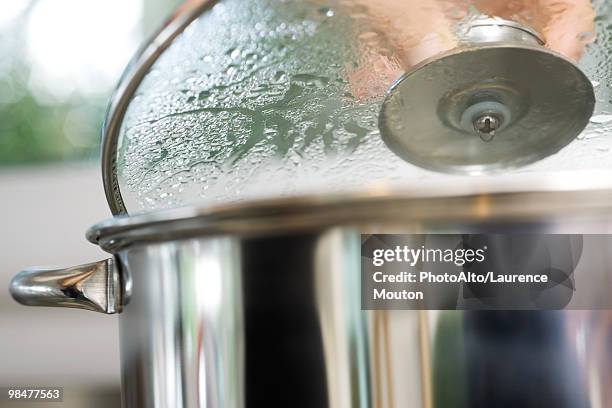 person removing lid from steaming pot - lid stock pictures, royalty-free photos & images