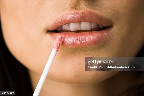 applying lip-gloss with lip brush - lipgloss stockfoto's en -beelden