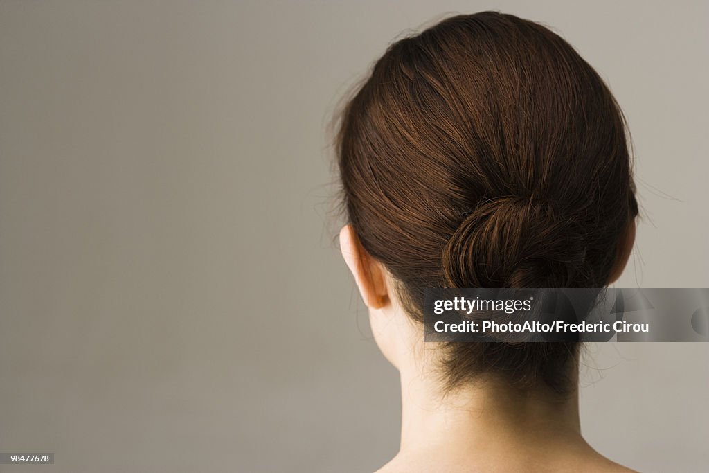 Woman with hair arranged in chignon, rear view