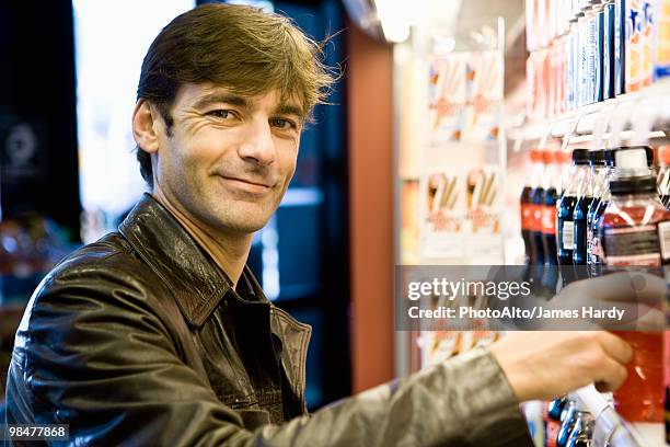 man at soft drink cooler in convenience store - beverage fridge stock pictures, royalty-free photos & images