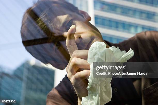 man scrutinizing spot on car window glass - obsessive stockfoto's en -beelden