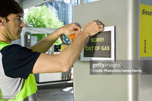 gas station attendant posting sign at gas pump reading "sorry out of gas - station service france stock pictures, royalty-free photos & images