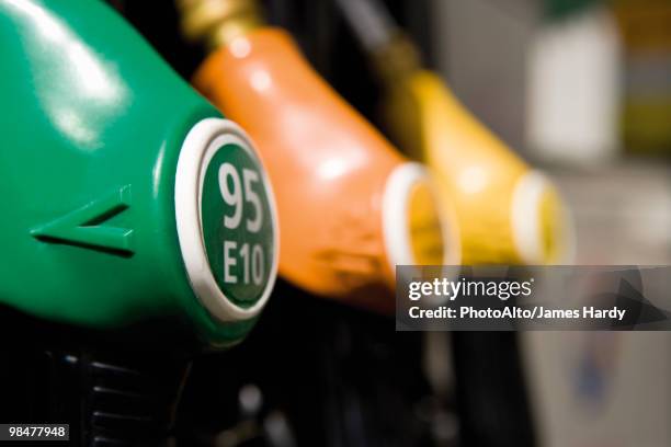 gas pump nozzles in a row - bomba de combustible fotografías e imágenes de stock