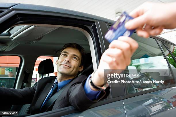 customer in drive-thru handing credit card to check-out window clerk - drive through fotografías e imágenes de stock