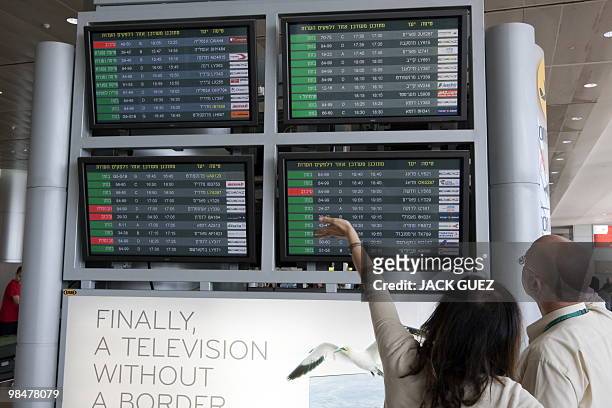 Passengers check the flight information monitor at Israel's Ben Gurion Airport, near Tel Aviv, after the cancellation on April 15, 2010 of several...