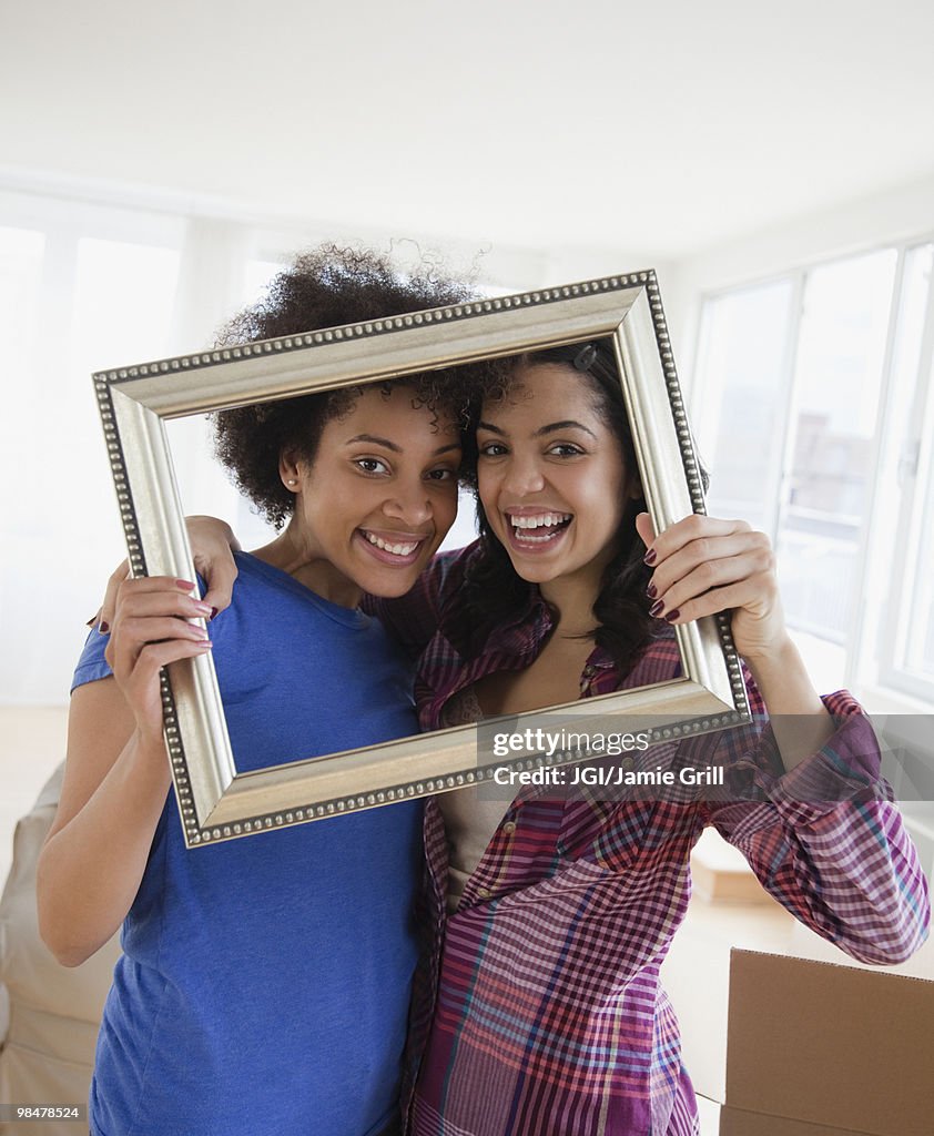 Friends looking through empty frame