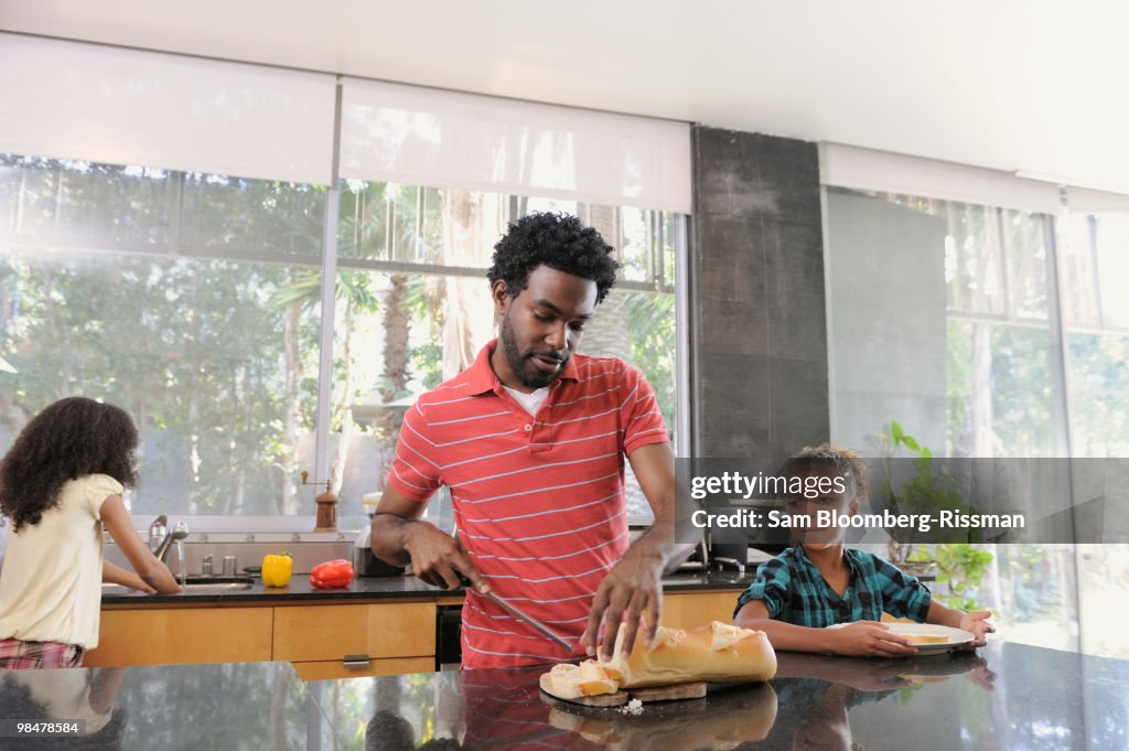 Father and daughters preparing food in kitchen