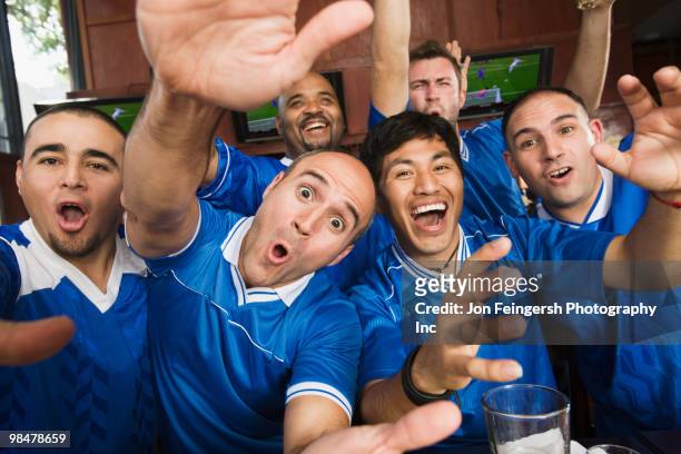 cheering teammates in sports bar - jon feingersh stock pictures, royalty-free photos & images