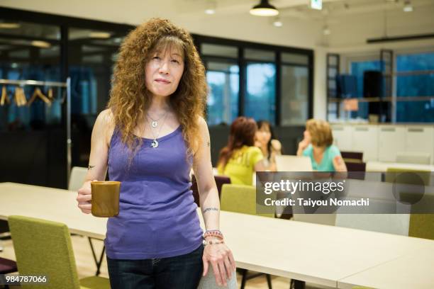 a woman entrepreneur who puts a tattoo to show a smile at a new office - hachioji fotografías e imágenes de stock