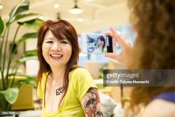 women enjoy shooting with smartphones between jobs - hachioji fotografías e imágenes de stock