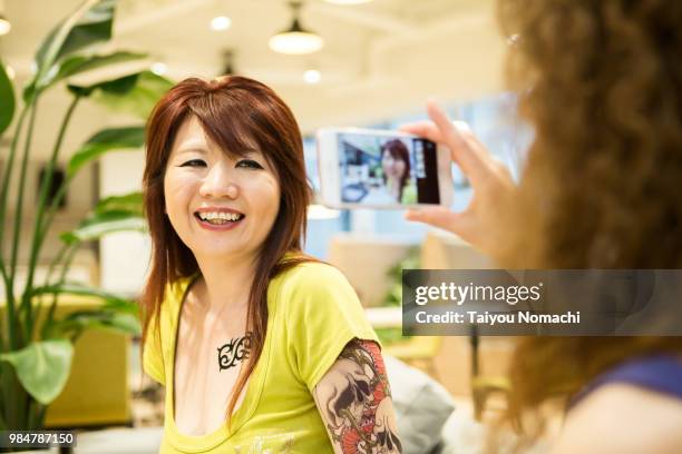 women enjoy shooting with smartphones between jobs - hachioji stock pictures, royalty-free photos & images