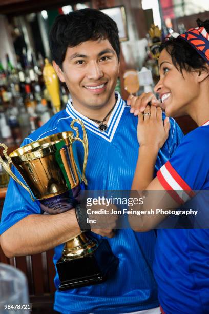 woman hugging boyfriend with trophy - jon feingersh stock pictures, royalty-free photos & images