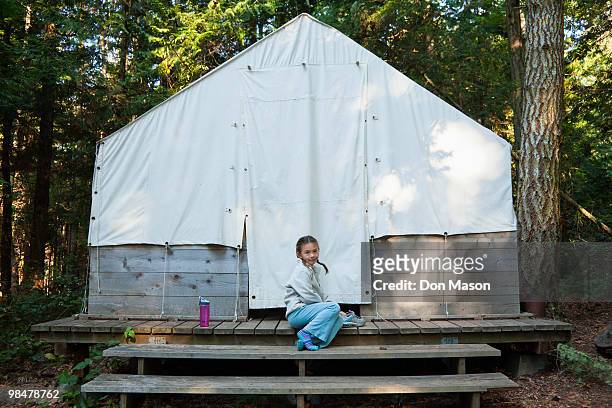 mixed race girl sitting near tent - don mason stock pictures, royalty-free photos & images