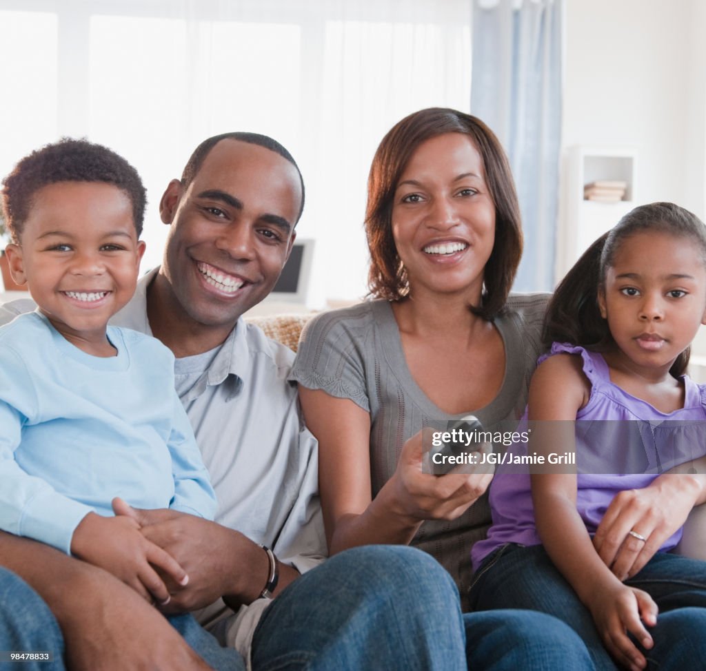 African American family watching television together