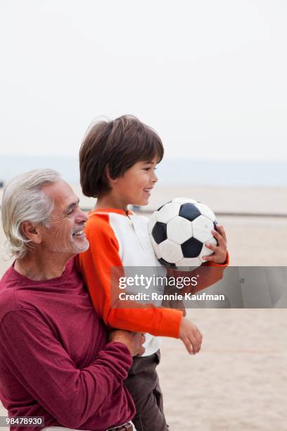 hispanic grandfather and grandson with soccer ball - grandparents raising grandchildren stock pictures, royalty-free photos & images