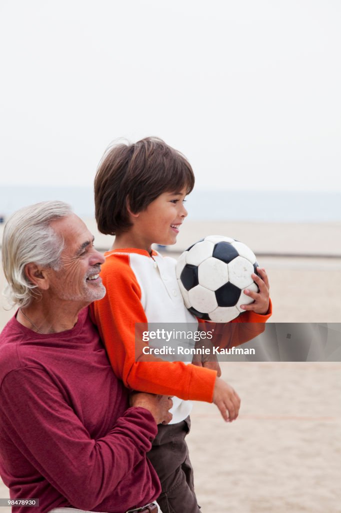 Hispanic grandfather and grandson with soccer ball