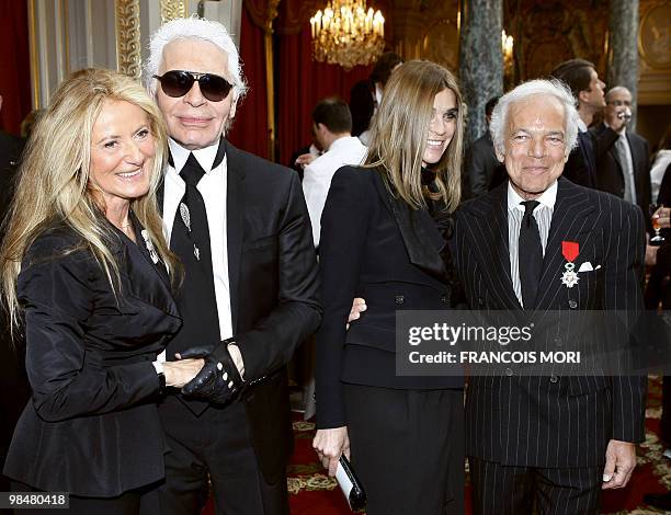 Fashion designer flanked by chief editor of the French edition of Vogue, Carine Roitfeld poses with German fashion designer Karl Lagerfeld and his...