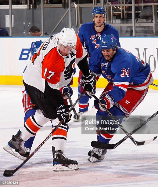 Aaron Voros of the New York Rangers skates against Jeff Carter of the Philadelphia Flyers on April 9, 2010 at Madison Square Garden in New York City....