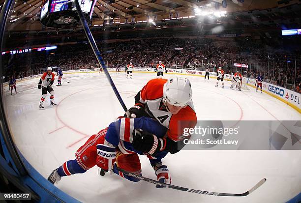Brandon Dubinsky of the New York Rangers is checked into the boards by Chris Pronger of the Philadelphia Flyers on April 9, 2010 at Madison Square...