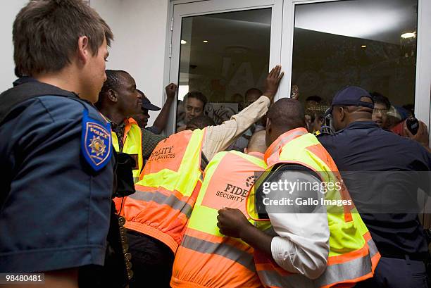 Police and security guards try to control the crowds of people pushing against doors at a 2010 FIFA World Cup ticket sales office in Brooklyn Mall on...