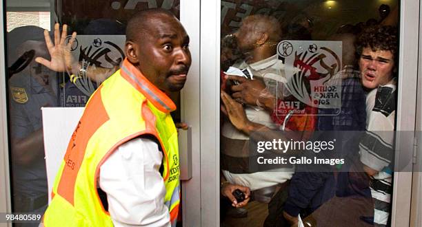 Security guards panicks as South African student Gordon Bolson is pressed against a glass door at a 2010 FIFA World Cup ticket sales office in...
