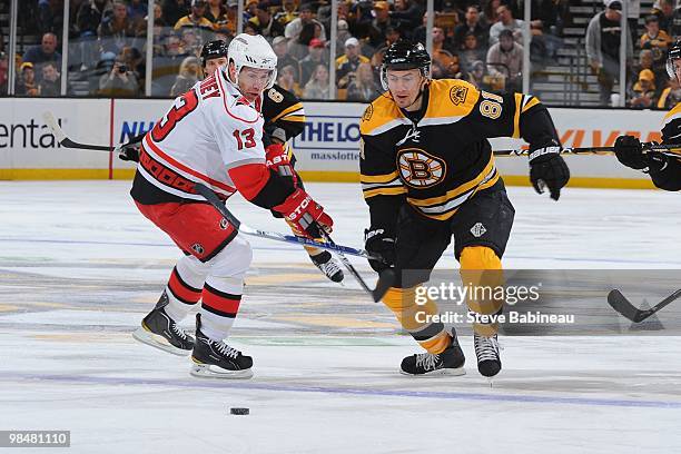 Miroslav Satan of the Boston Bruins skates up ice with the puck against Ray Whitney of the Carolina Hurricanes at the TD Garden on April 10, 2010 in...