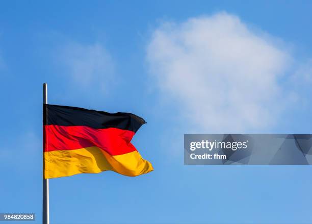 german flag with blue sky (berlin, germany) - german flag fotografías e imágenes de stock