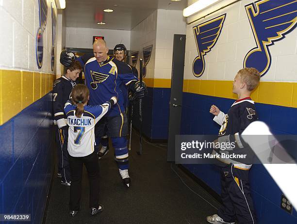 Keith Tkachuk of the St. Louis Blues greets his children Braeden Taryn and Matthew as he heads to the ice for warmups prior to the last home game of...