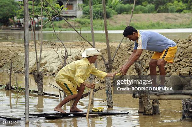 Man uses a makeshift raft to move around the flooded Salitre, 600 km southwest of the Ecuadorean capital Quito, on April 15, 2010. Landslides and...