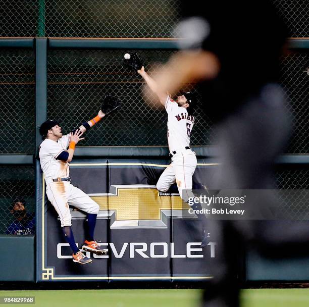 Jake Marisnick of the Houston Astros makes a catch on a fly ball by Justin Smoak of the Toronto Blue Jays at the wall as Josh Reddick looks on in the...