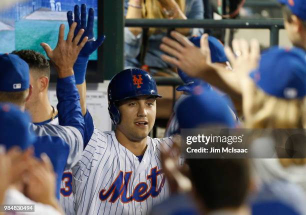 Michael Conforto of the New York Mets celebrates his seventh inning home run against the Pittsburgh Pirates with his teammates in the dugout at Citi...