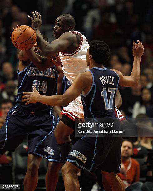 Loul Deng of the Chicago Bulls looses control of the ball when he is fouled by C.J. Miles of the Utah Jazz as he tries to drive between Miles and...