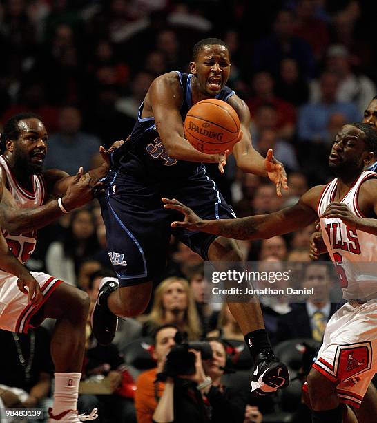 Miles of the Utah Jazz leaps to try and recover the ball between Chris Richard and Ronald Murray of the Chicago Bulls at the United Center on March...