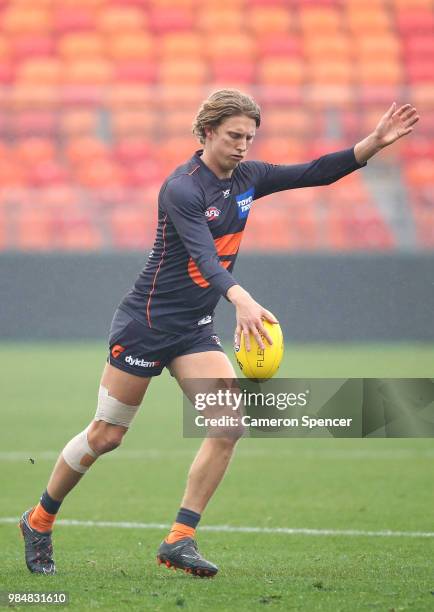 Lachie Whitfield of the Giants kicks during a Greater Western Sydney Giants AFL training session at Spotless Stadium on June 27, 2018 in Sydney,...