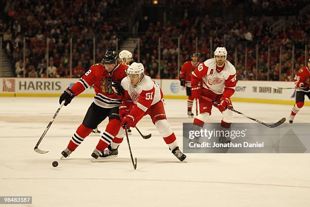 Patrick Kane of the Chicago Blackhawks tries to control the puck against Valtteri Filppula of the Detroit Red Wings applies defensive pressure at the...