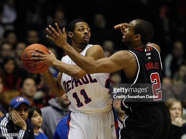 Jeremiah Kelly of the DePaul Blue Demons tries to pass under pressure from Preston Knowles of the Louisville Cardinals at the Allstate Arena on...