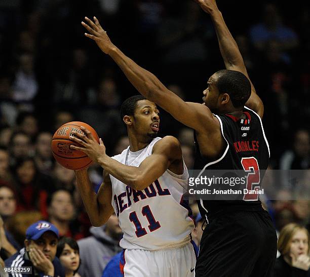 Jeremiah Kelly of the DePaul Blue Demons tries to pass under pressure from Preston Knowles of the Louisville Cardinals at the Allstate Arena on...