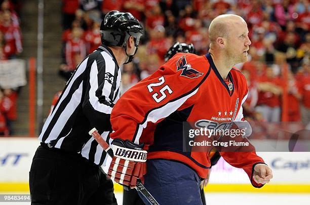Jason Chimera of the Washington Capitals is led off the ice by linesman Greg Devorski after getting a penalty against the Boston Bruins at the...