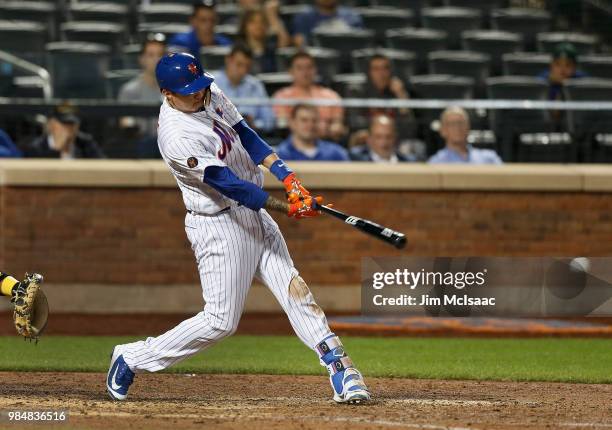 Wilmer Flores of the New York Mets connects on his tenth inning game winning single against the Pittsburgh Pirates at Citi Field on June 26, 2018 in...