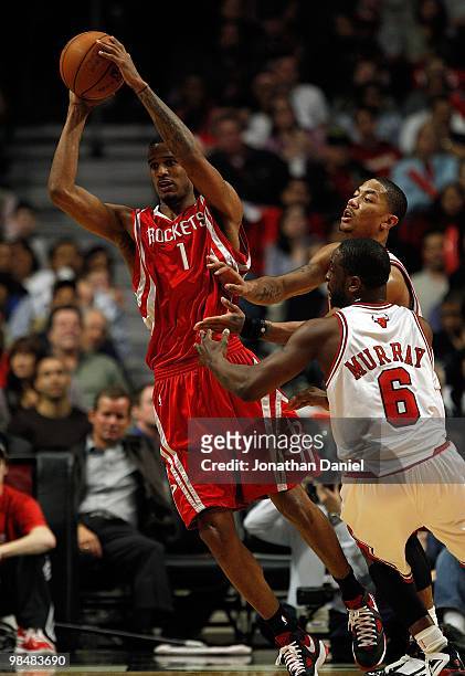 Trevor Ariza of the Houston Rockets passes the ball under pressure from Ronald Murray and Derrick Rose of the Chicago Bulls at the United Center on...